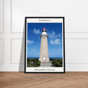 Puede incluir: Impresión enmarcada de un faro beige con techo rojo, sobre un cielo azul con nubes. La impresión lleva las etiquetas "AUSTRALIA" y "KANGAROO ISLAND". El faro está sobre un acantilado verde cubierto de arbustos.