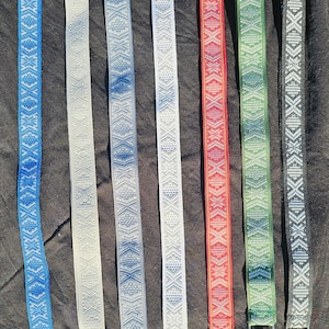 Puede incluir: Ocho cordones tejidos de colores con llaveros plateados. Los cordones presentan un patr&oacute;n geom&eacute;trico con detalles blancos. Los colores son azul, blanco, azul claro, blanco, rojo, verde y negro.