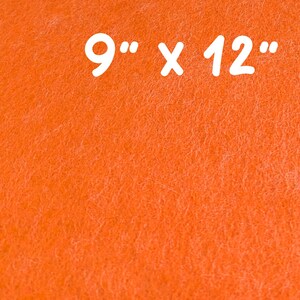 May include: Close-up of an orange felt sheet. The text "9" x 12"" is printed in white. The felt has a textured surface. The dimensions are 9 inches by 12 inches.