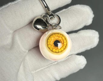 Llavero artesanal de ojo amarillo / Llavero de resina con corazón plateado