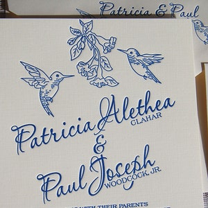 May include: Cream-colored wedding invitation suite with navy blue hummingbird illustrations and floral accents. The invitation features the names "Patricia & Paul" and "Patricia Alethea & Paul Joseph, Jr." in elegant script.
