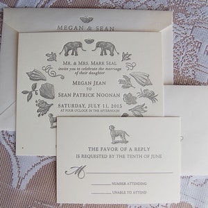 May include: Cream-colored wedding invitation suite with an envelope, invitation, and RSVP card. The invitation features the names "Megan & Sean" and details of the wedding, including the date, time, and names of the couple. Decorative illustrations include elephants, shells, and a dog.