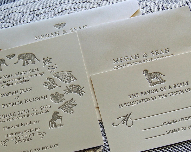 May include: Ivory wedding invitations with embossed details. The invitations feature the names "Megan & Sean" and include illustrations of animals and foliage. The RSVP card has a dog illustration.