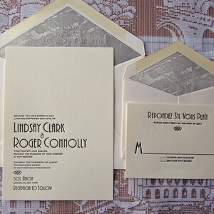 May include: Cream-colored wedding invitation suite with matching envelopes. The invitation features the names Lindsay Clark and Roger Connolly, along with wedding details. The RSVP card reads "R&eacute;pondez S'il Vous Pla&icirc;t". The envelopes have a gray patterned interior.