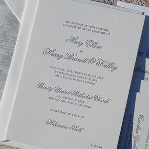 May include: Elegant wedding invitations with gray script on textured white paper. The text includes the names Mary Ellen and Henry Brandt O'Kelley, the date, time, and location of the ceremony at Trinity United Methodist Church.