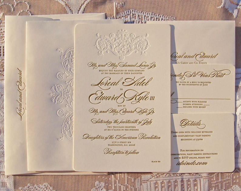 May include: Elegant ivory wedding invitation suite with gold foil lettering and embossed floral details. Includes invitation, RSVP, and details cards. Features the names Loreal and Edward.