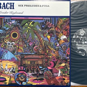 May include: A vinyl record album cover for J.S. Bach's "Six Preludes & Fuga" by Robert Kreider. The cover features a colorful, psychedelic illustration with text in white and black. The record itself is black.