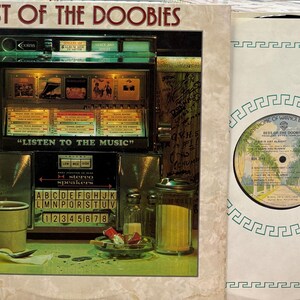 May include: Album cover for "Best of the Doobies" featuring a vintage jukebox with the text "Listen to the Music." A vinyl record is visible on the right. The album art has a retro diner theme with a mug, condiments, and a plate of food.