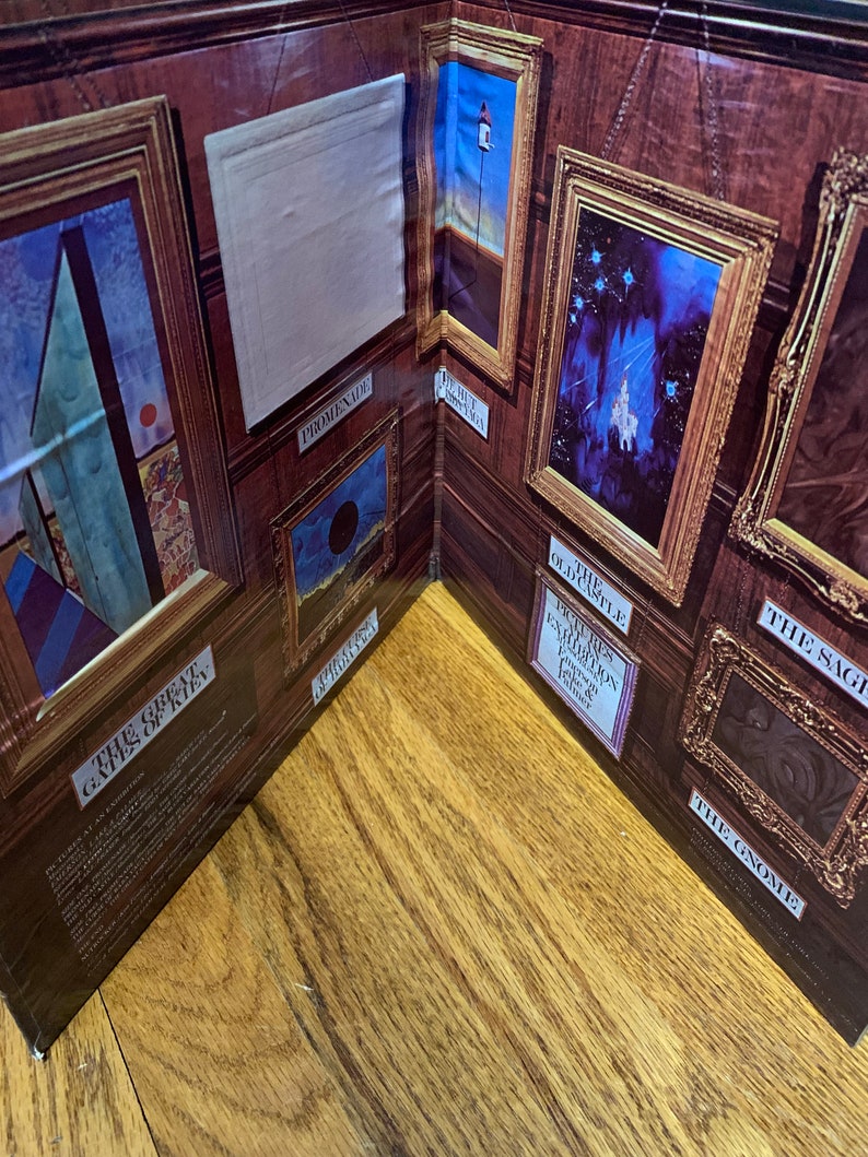 Pu&ograve; includere: Un diorama raffigurante una galleria con opere d'arte incorniciate. Le pareti della galleria sono marroni con dipinti con cornice dorata. Le opere d'arte includono un faro, un castello e un cerchio nero. Il testo include "Promenade" e "The Gnome".
