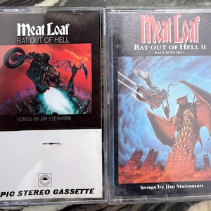 May include: Two cassette tapes of Meat Loaf albums. The first, "Bat Out of Hell," features a motorcycle illustration on a red and black background. The second, "Bat Out of Hell II: Back Into Hell," has a winged creature illustration on a blue background.