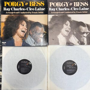 May include: Two vinyl records of "Porgy & Bess" by Ray Charles and Cleo Laine. The album cover features a color photo of the artists, with the text "PORGY & BESS" and artist names. The RCA logo is visible. The records are in white paper sleeves.