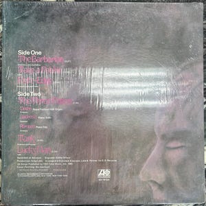 May include: A vinyl record album cover with song titles including "The Barbarian" and "Lucky Man." The cover displays a profile of a person's face and the Atlantic Records logo. The album is in a plastic sleeve.