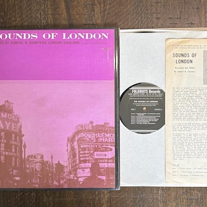 May include: A vintage vinyl record album titled "The Sounds of London" with a pink and brown cover featuring a London street scene. The album includes a record, a white sleeve, and a booklet with text and a map.