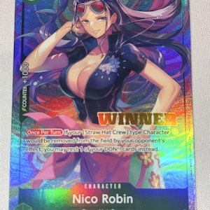May include: A holographic One Piece trading card featuring Nico Robin with purple hair and sunglasses, wearing a dark blue zip-up top. The card displays the text WINNER, a power level of 4000, and game instructions regarding the Straw Hat Crew.