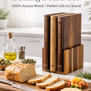 May include: A book-shaped cutting board set made of acacia wood. The set includes a wooden stand and three cutting boards designed to look like books. The boards are labeled "Fruits & Vegetables", "Cheese & Bread", and "Meats & Seafood". Sliced bread, cheese, and a knife are on the cutting board.