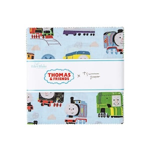 May include: A stack of fabric squares featuring a light blue background with colorful illustrations of Thomas the Tank Engine and his friends. The fabric is branded with the "Thomas & Friends" logo and the Riley Blake Designs logo.