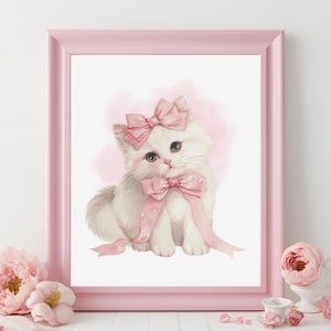 May include: A white kitten wearing a pink bow with polka dots and a pink ribbon, sitting on a white background.