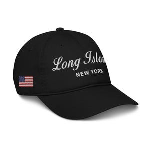 May include: Black baseball cap with a white embroidered design that says "Long Island New York" and a small American flag on the side.