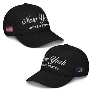 May include: Two black baseball caps with white embroidered text that reads "New York United States". One cap features a small American flag patch and the other features a small New York state flag patch.