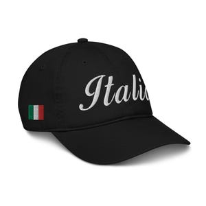 Może przedstawiać: Czarna czapka bejsbolówka z haftowanym na biało napisem "Italia" i małą włoską flagą z boku.