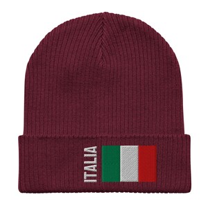 May include: A maroon knitted beanie with a white embroidered Italian flag and the word "ITALIA" on the front.