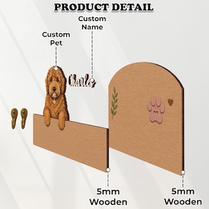 K&ouml;nnte beinhalten: Ein h&ouml;lzernes Wanddisplay mit einem braunen Hunde-Ausschnitt, dem personalisierten Namen "Charles" und einem abgerundeten Brett, das mit einem gr&uuml;nen Blatt, einer rosa Pfote und einem kleinen Herz verziert ist. Zwei bronzefarbene Metallhaken.
