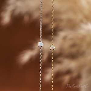 May include: Two delicate necklaces with opal stones. One necklace is silver and the other is gold.
