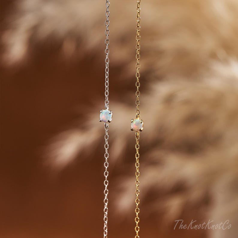 May include: Two delicate necklaces with opal stones. One necklace is silver and the other is gold.