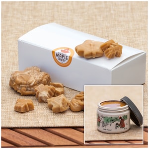 May include: A white box with a label that says "Canada Maple Candy Ltd." and a picture of a maple leaf. The box contains maple candy shaped like maple leaves. A jar of maple cream is also pictured. The jar is labeled "Pure Maple Cream, Half Pound, 8 oz."