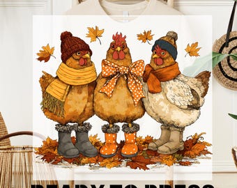 May include: DTF TRANSFER and READY TO PRESS text above and below a graphic of three chickens wearing fall attire. The chickens are wearing hats, scarves, and boots, standing on a bed of autumn leaves. The chickens are brown, orange, and white.