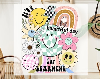May include: A colorful iron-on transfer design featuring a rainbow, flowers, and smiley faces with the text "It's a beautiful day for learning".