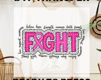 May include: A white t-shirt with a pink ribbon and the word "FIGHT" in black letters with pink polka dots. The words "believe, hope, strength, courage, faith, family, love, support, awareness" are written around the design.
