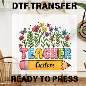 May include: White t-shirt featuring a vibrant floral design and the word "TEACHER" in colourful bubble letters. A yellow pencil graphic with the word "Custom" is below the word TEACHER. The words "DTF TRANSFER" and "READY TO PRESS" are above and below the design.