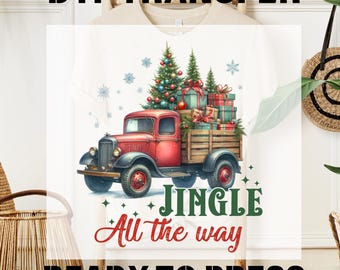 Op de afbeelding: Wit T-shirt met een DTF-transfer. Het ontwerp toont een rode vintage truck met een kerstboom en cadeaus. De tekst luidt "Jingle All the Way" en "Ready to Press".