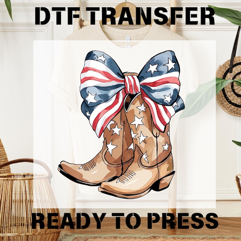 May include: A DTF transfer design featuring a pair of cowboy boots with white stars and a bow in the colors of the American flag. The words "DTF TRANSFER" and "READY TO PRESS" are printed above and below the design.