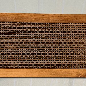 May include: A wooden frame with a brown cardboard honeycomb pattern inside. The frame is made of natural wood and has a rustic look.