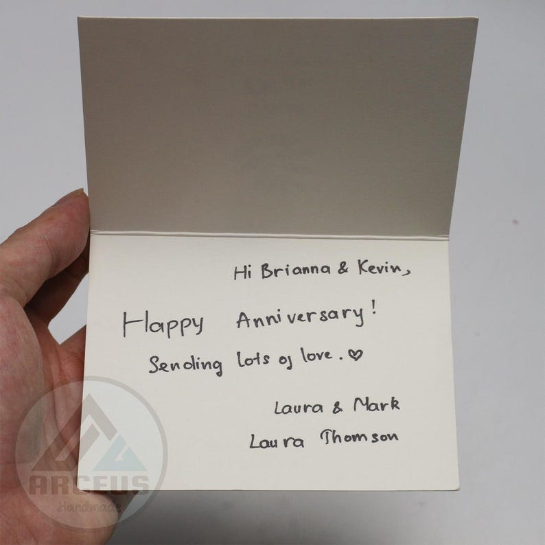 May include: A handwritten card with the text "Hi Brianna & Kevin, Happy Anniversary! Sending lots of love.♡ Laura & Mark Laura Thomson"