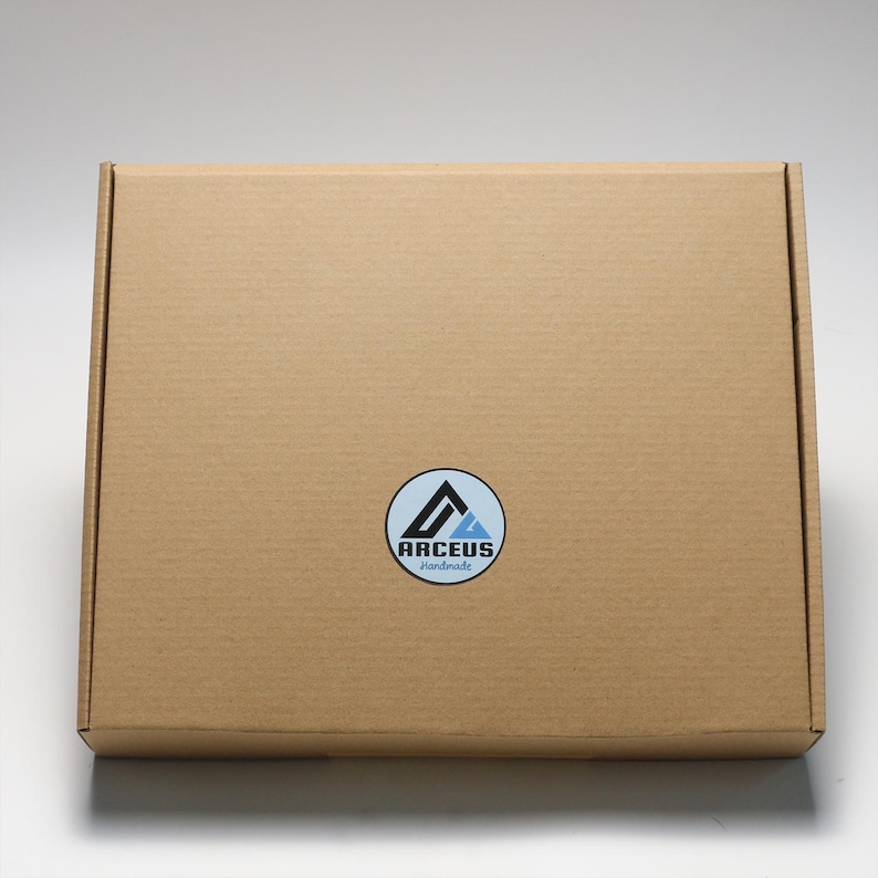 May include: A brown cardboard box with a white circle sticker that says "ARCEUS handmade" in black text. The sticker has a blue and black mountain logo.