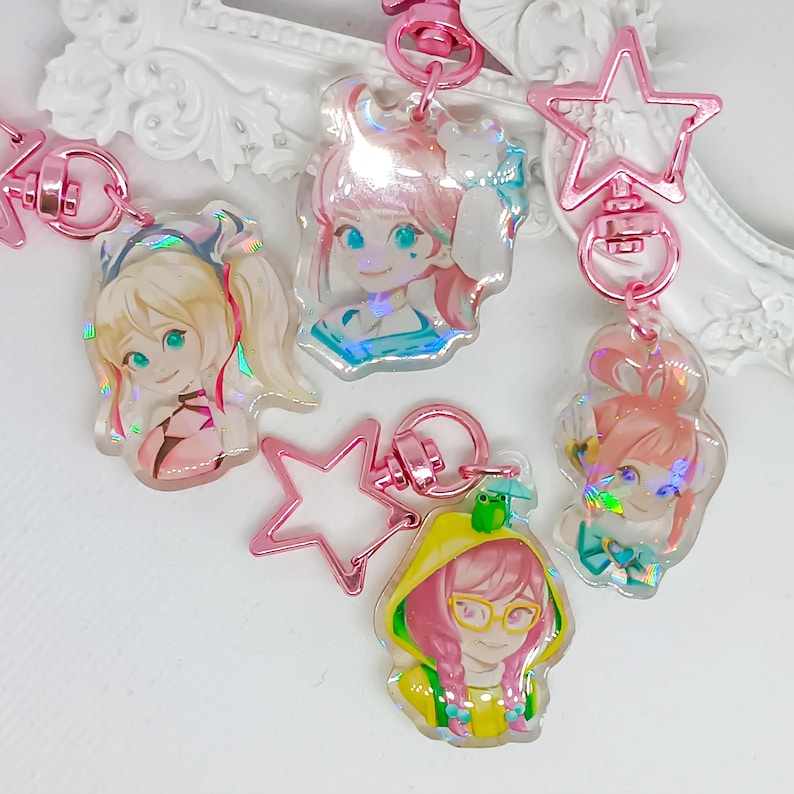 Overwatch mini keychains featuring Pink Mercy, Dokiwatch Juno, Rainy Day Kiriko, and Rainy Day Mei. Each is 1.5 inches with double-sided glitter epoxy and a broken glass holographic effect on one side. Cute Overwatch gift for support mains, gamer girls, and fans of OW2 skins and collectibles. Great for bags, backpacks, and keys. Handmade fanmade merchandise for Overwatch lovers and kawaii gaming aesthetic. Painted and produced by Chryssv.