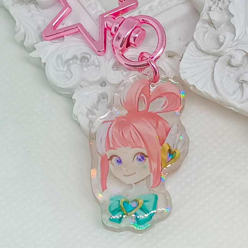 Overwatch mini keychains featuring Pink Mercy, Dokiwatch Juno, Rainy Day Kiriko, and Rainy Day Mei. Each is 1.5 inches with double-sided glitter epoxy and a broken glass holographic effect on one side. Cute Overwatch gift for support mains, gamer girls, and fans of OW2 skins and collectibles. Great for bags, backpacks, and keys. Handmade fanmade merchandise for Overwatch lovers and kawaii gaming aesthetic. Painted and produced by Chryssv.