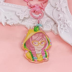 Overwatch mini keychains featuring Pink Mercy, Dokiwatch Juno, Rainy Day Kiriko, and Rainy Day Mei. Each is 1.5 inches with double-sided glitter epoxy and a broken glass holographic effect on one side. Cute Overwatch gift for support mains, gamer girls, and fans of OW2 skins and collectibles. Great for bags, backpacks, and keys. Handmade fanmade merchandise for Overwatch lovers and kawaii gaming aesthetic. Painted and produced by Chryssv.