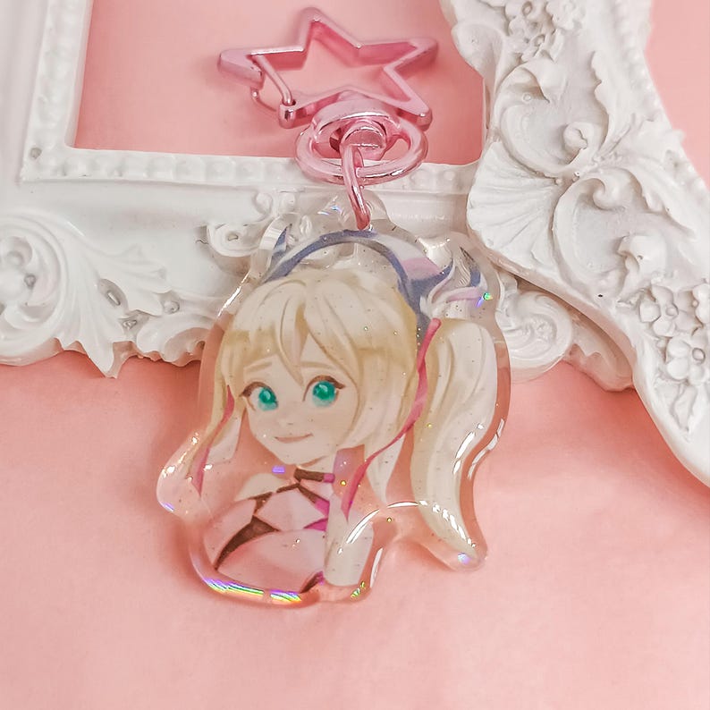 Overwatch mini keychains featuring Pink Mercy, Dokiwatch Juno, Rainy Day Kiriko, and Rainy Day Mei. Each is 1.5 inches with double-sided glitter epoxy and a broken glass holographic effect on one side. Cute Overwatch gift for support mains, gamer girls, and fans of OW2 skins and collectibles. Great for bags, backpacks, and keys. Handmade fanmade merchandise for Overwatch lovers and kawaii gaming aesthetic. Painted and produced by Chryssv.