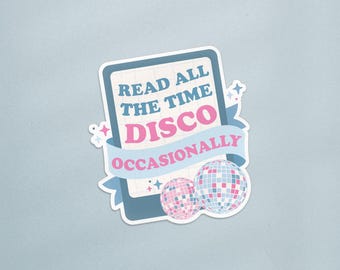 Op de afbeelding: Een sticker met de tekst "READ ALL THE TIME DISCO OCCASIONALLY" in blauw en roze. Het ontwerp bevat twee discoballen en een blauwe banner. De sticker heeft een witte rand en een lichtblauwe achtergrond.