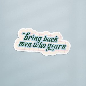 Op de afbeelding: Een sticker met de tekst "bring back men who yearn" in een donkergroen cursief lettertype. De tekst staat op een lichtgele achtergrond met een roze rasterpatroon. De sticker heeft een witte rand en staat op een lichtblauwe achtergrond.