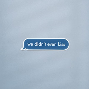 May include: A blue text bubble with white border and the text "we didn't even kiss" on a light blue background. The text bubble is a common design used in text messaging.