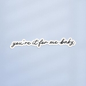 May include: A white sticker with the handwritten phrase "you're it for me baby" in black cursive script. The sticker is on a light blue background.