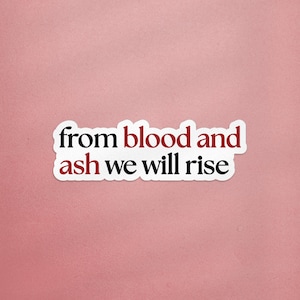 Könnte beinhalten: Ein weißer Aufkleber mit dem Text "from blood and ash we will rise" in schwarzer und roter Schrift. Der Aufkleber befindet sich auf einem rosa Hintergrund.