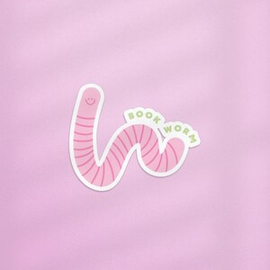 May include: Pink worm sticker with a smiling face and the text "BOOK WORM" in green.