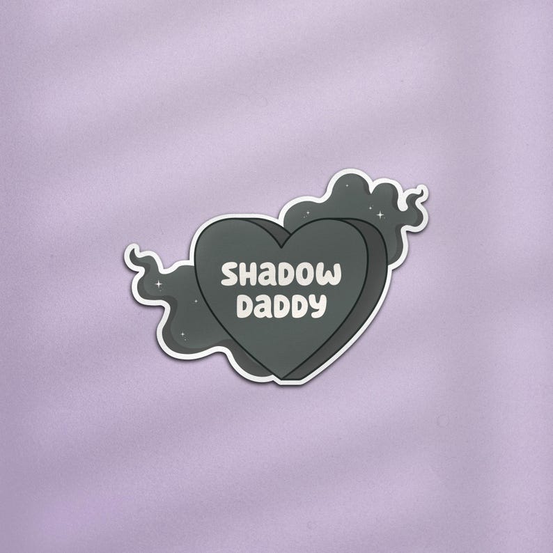May include: A black heart-shaped sticker with the text "Shadow Daddy" in white lettering. The sticker is surrounded by a black cloud with white stars.