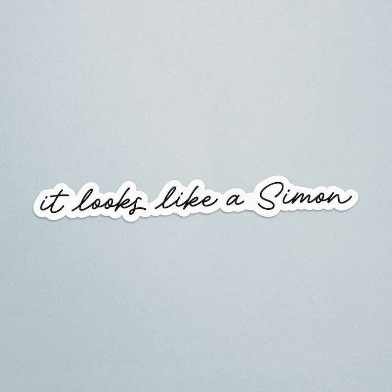 May include: A white sticker with the phrase "it looks like a Simon" in black cursive script. The sticker has a white border and is set against a light blue background.